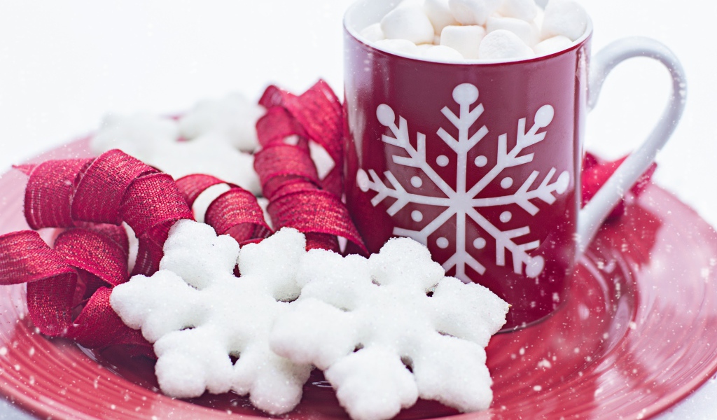 Чашка горячего шоколада с маршмеллоу на тарелке со снежинками
