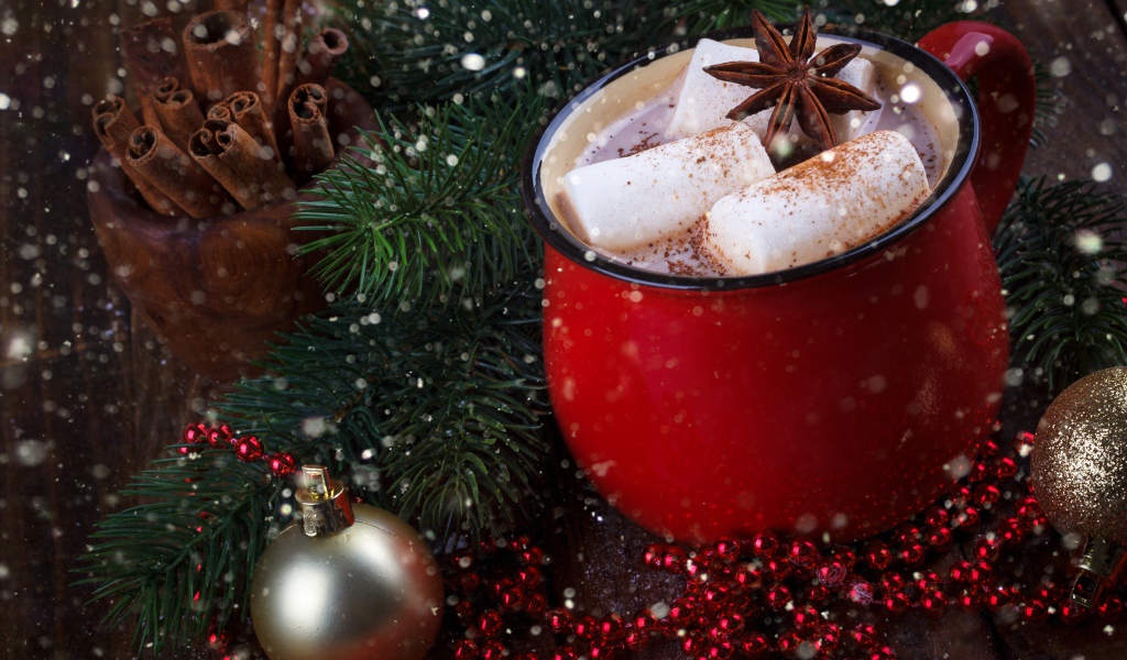 Чашка горячего какао с кусочками маршмеллоу и бадьяном на столе с еловой веткой 