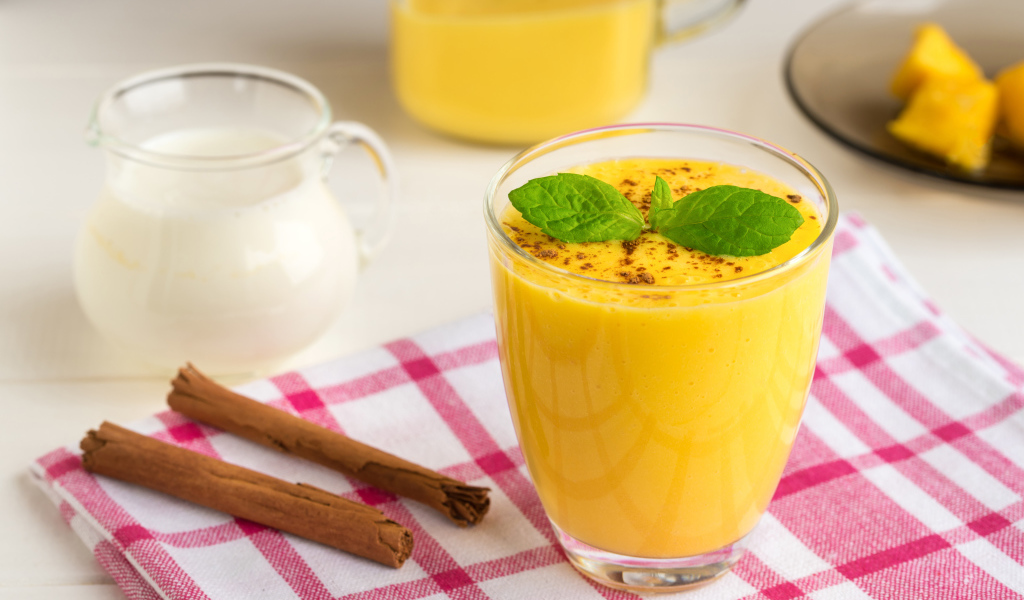 Стакан сока на столе с молоком и корицей