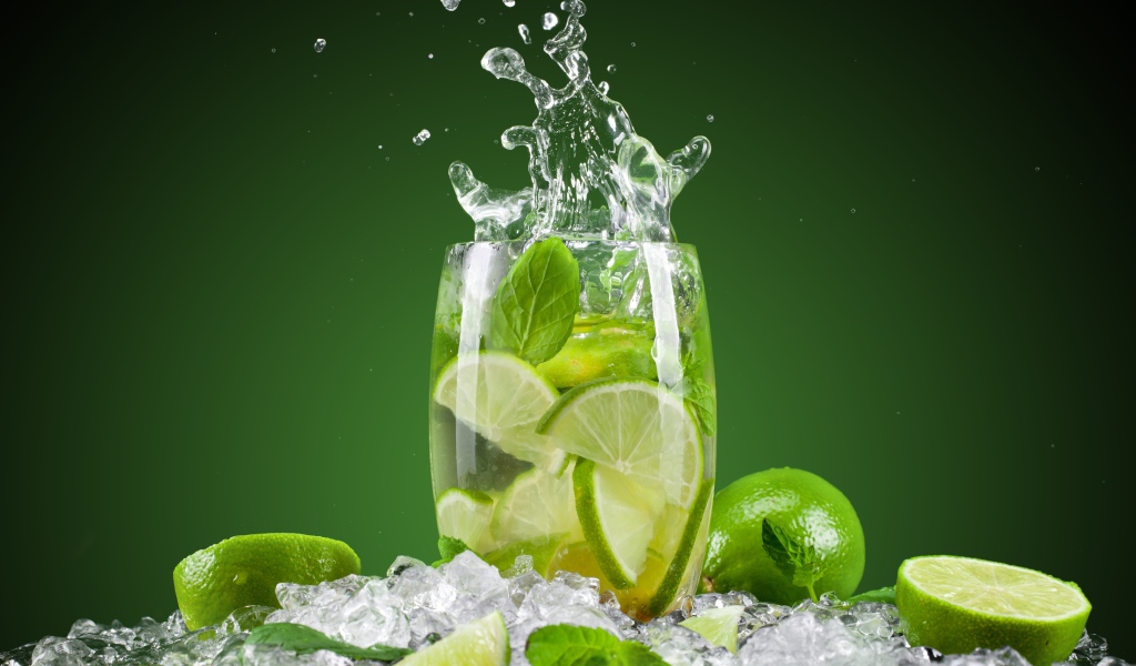 Стакан с лимонадом стоит на кусочках льда с лаймом