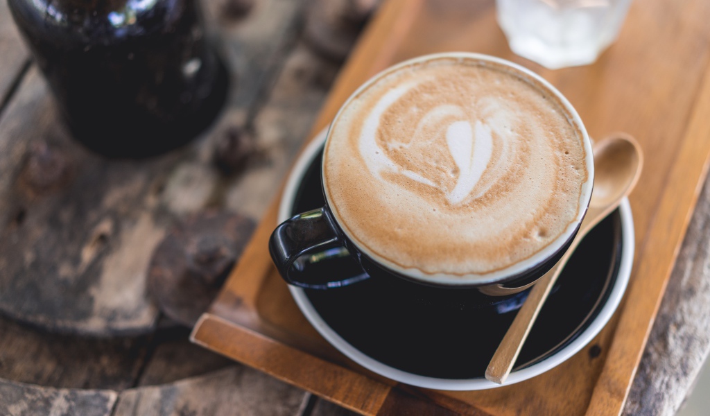 Большая чашка кофе с пеной на столе