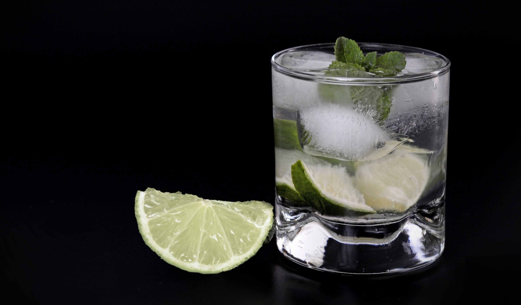 Коктейль кайпиринья на черном фоне с кусочком лайма