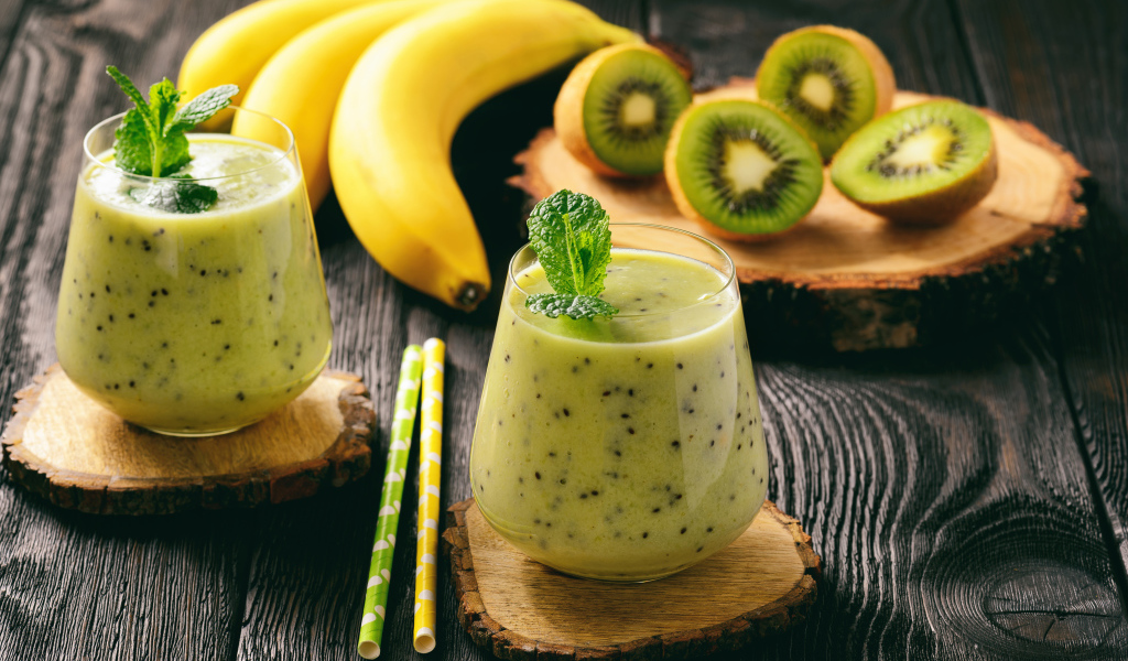 Коктейль с киви и бананами в стаканах на столе