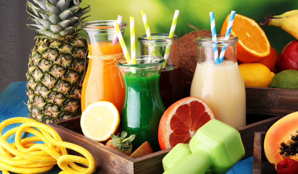 Коктейли в бутылках с трубочками на столе фруктами