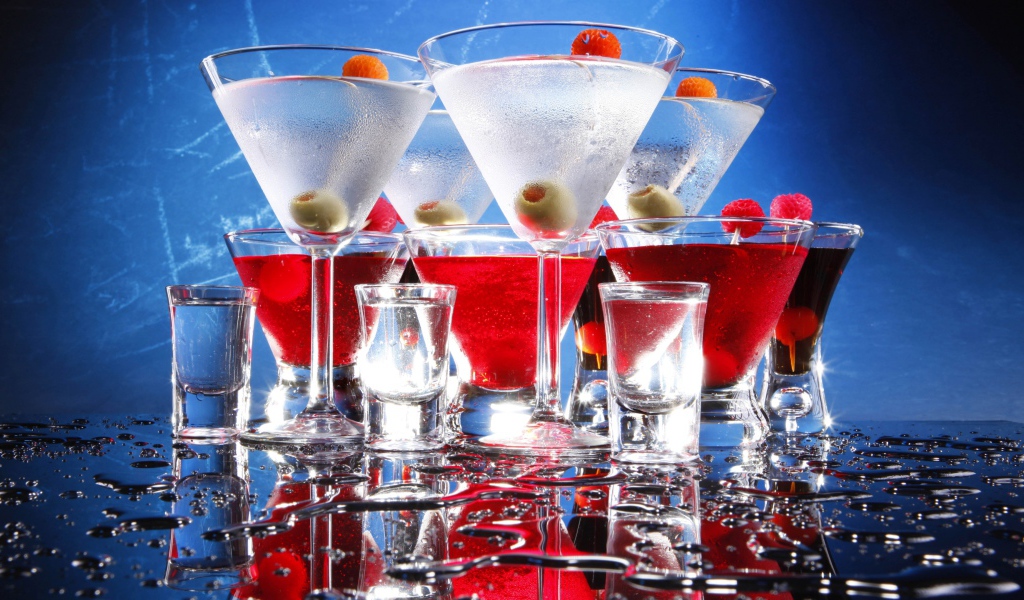Коктейли с рюмками на мокром столе