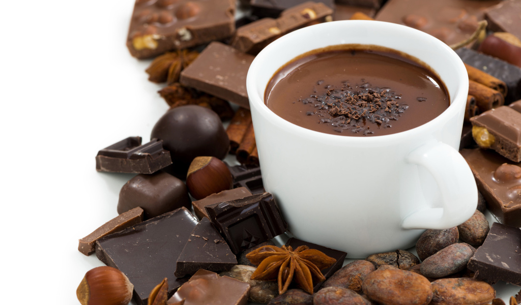 Горячий шоколад в белой чашке на столе с орехами
