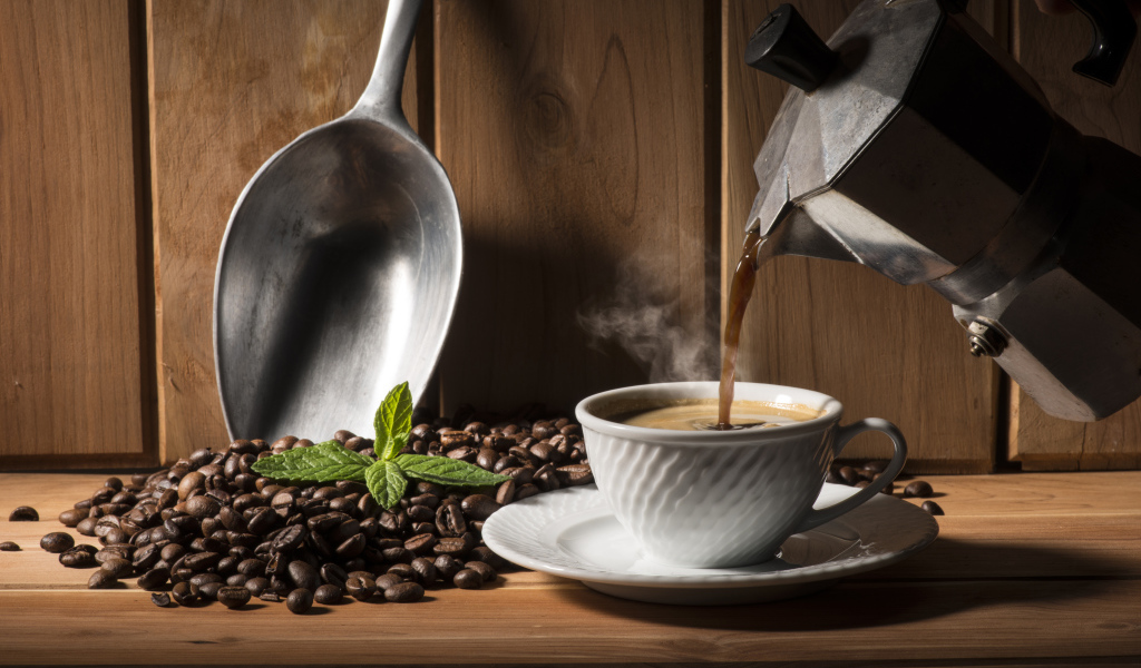 Горячий кофе наливают в чашку на столе с кофейными зернами