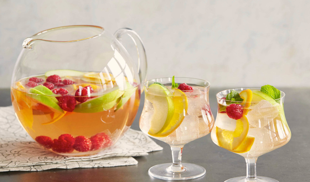 Лимонад в графине на столе с бокалами 