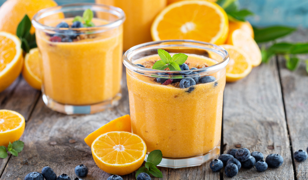 Апельсиновый сок в стакане с ягодами черники