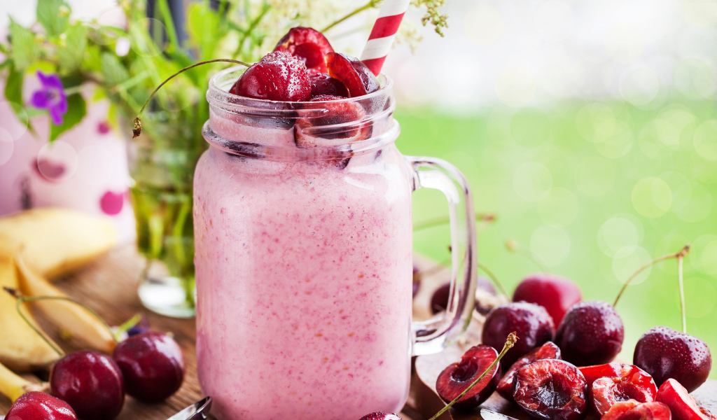 Смузи в бутылке с трубочкой и ягодами черешни 