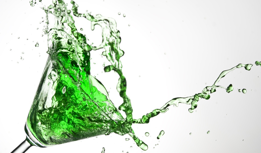 Splashes of green cocktail on a gray background