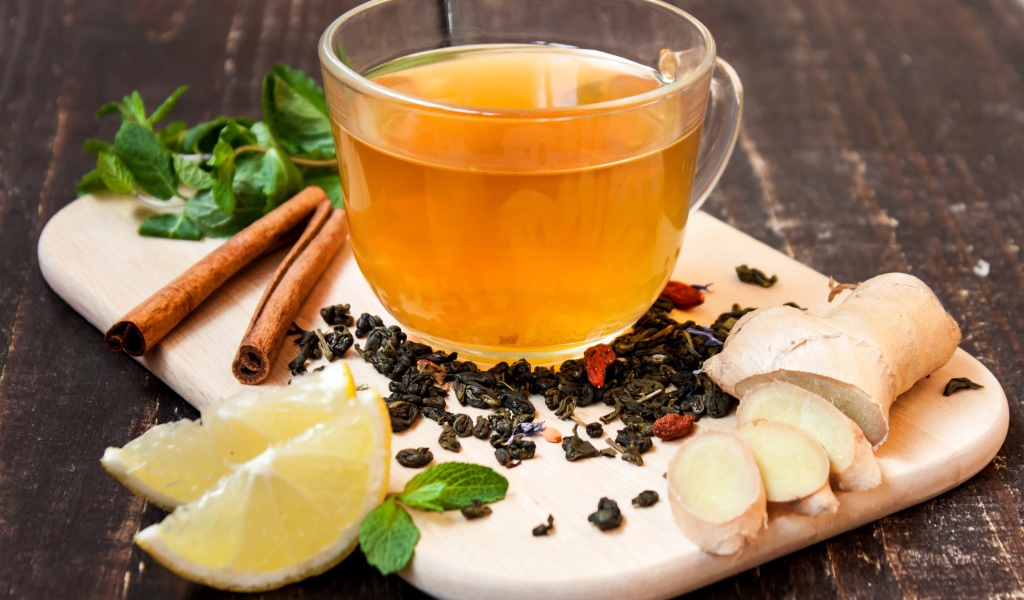 Чай с имбирем, лимоном, корицей и мятой на разделочной доске