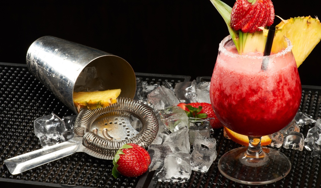 Тропический коктейль в бокале на столе со льдом