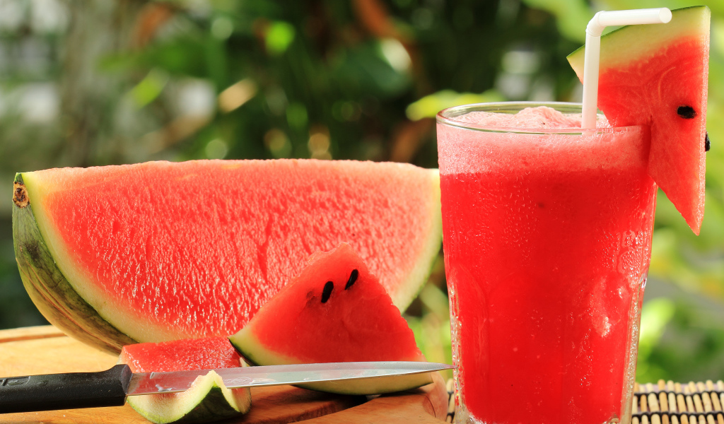 Арбузный напиток в стакане на столе с куском арбуза