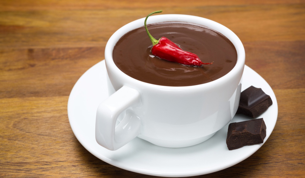 Белая чашка горячего шоколада с красным перцем