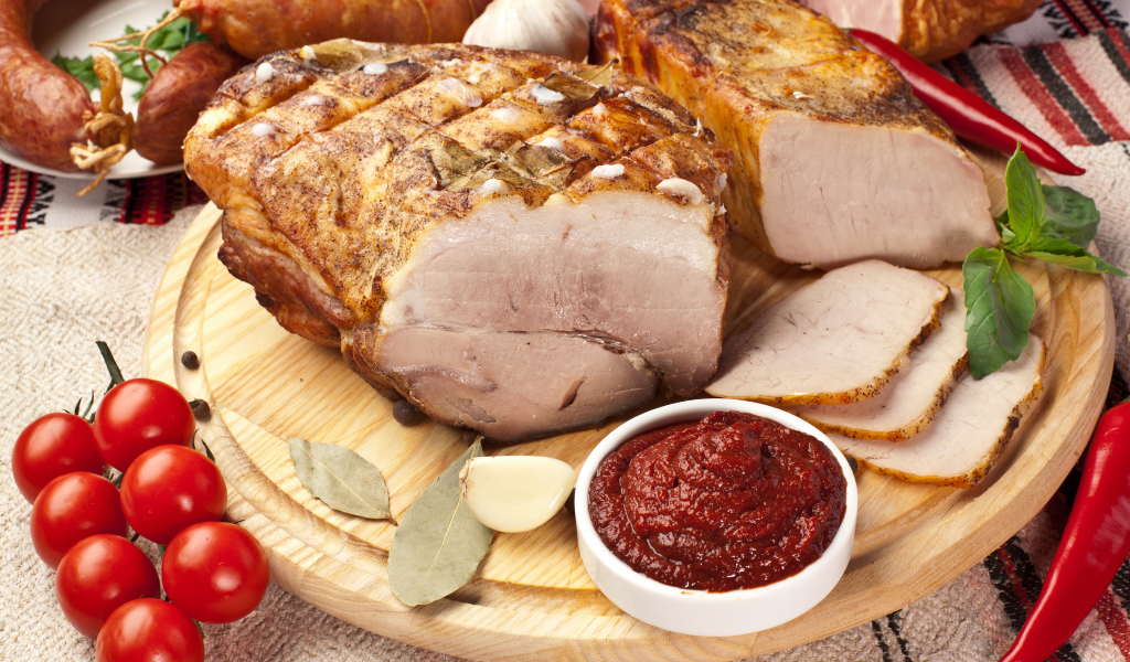 Аппетитная ветчина на столе с соусом и помидорами