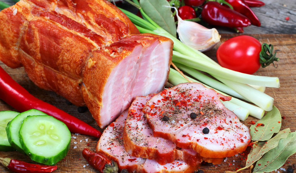 Аппетитная ветчина со специями и свежими овощами на столе