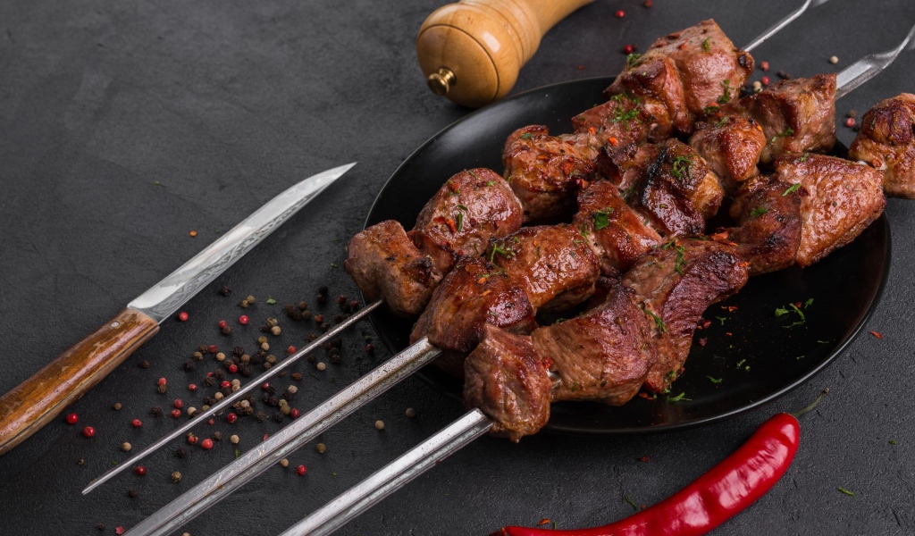 Аппетитный мясной шашлык на столе с перцем 
