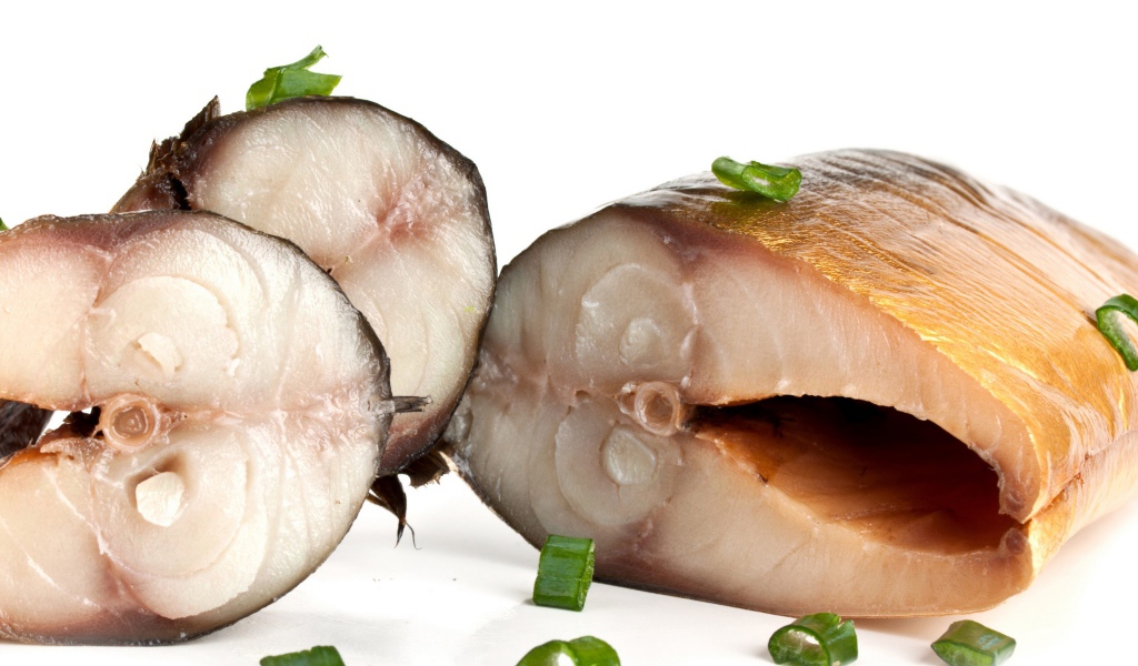 Аппетитная копченая скумбрия с зеленым луком на белом фоне