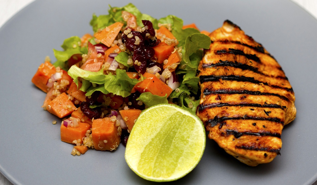 Мясо барбекю с овощами и лаймом на серой тарелке 