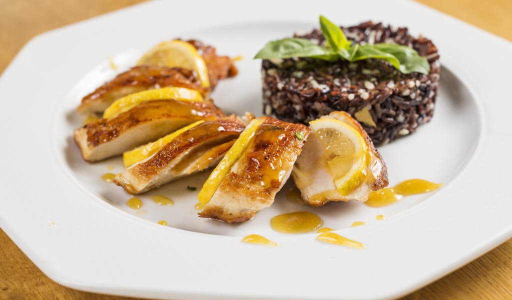 Куриный рулет на белой тарелке с рисом