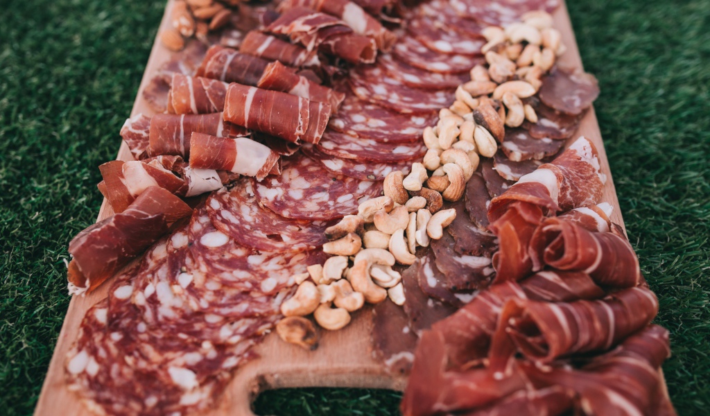 Мясная нарезка с орехами на разделочной доске