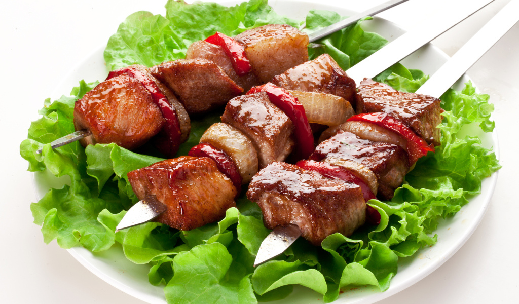 Аппетитный шашлык с листьями салата на шампурах 