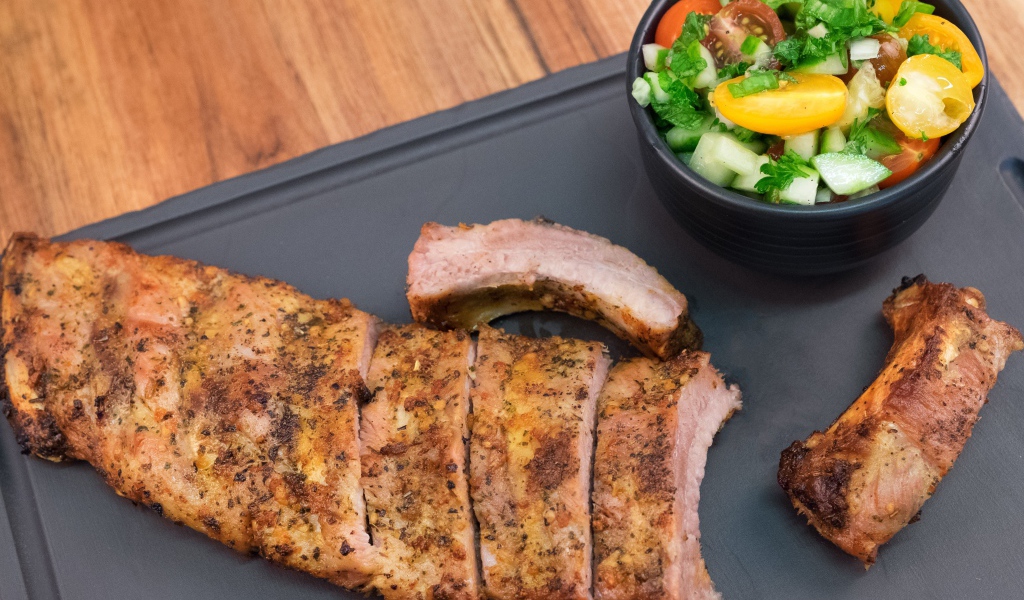 Жареные ребрышки с салатом на столе