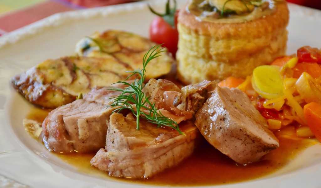 Мясо свинина на тарелке с соусом