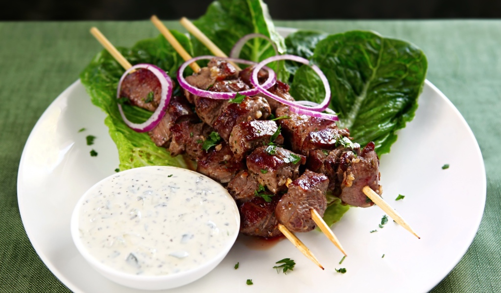 Вкусный шашлык на деревянных шампурах с соусом