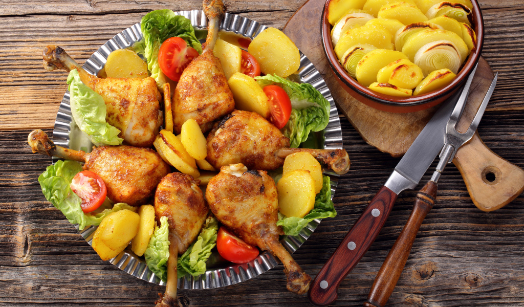 Запеченные куриные ножки с жареной картошкой на столе
