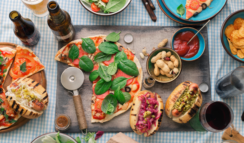 Пицца с хотдогами на столе с соусом