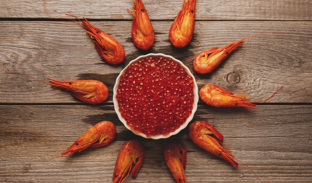 Вареные креветки на столе с красной икрой