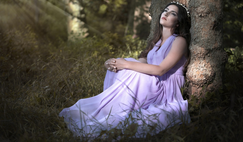 Девушка в красивом платье под деревом 