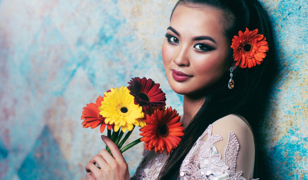 Красивая девушка азиатка с букетом гербер в руках