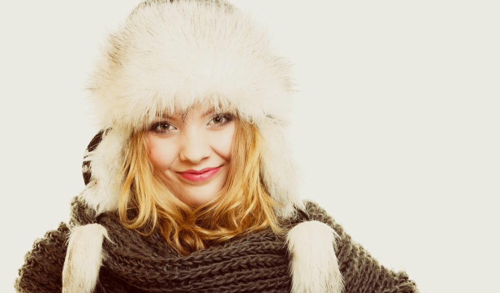 Красивая блондинка в теплой шапке с шарфом на шее