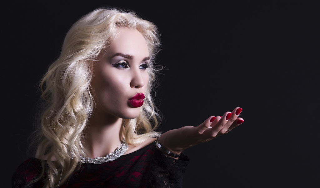 Красивая голубоглазая блондинка с красными губами в черном платье