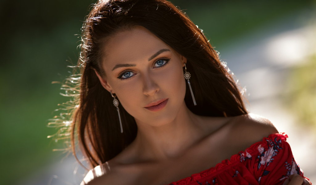 Красивая голубоглазая брюнетка с серьгами у ушах