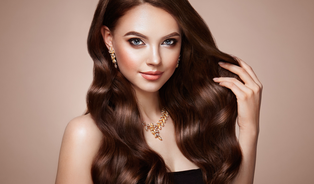 Красивая голубоглазая длинноволосая девушка шатенка с золотым украшением на шее 
