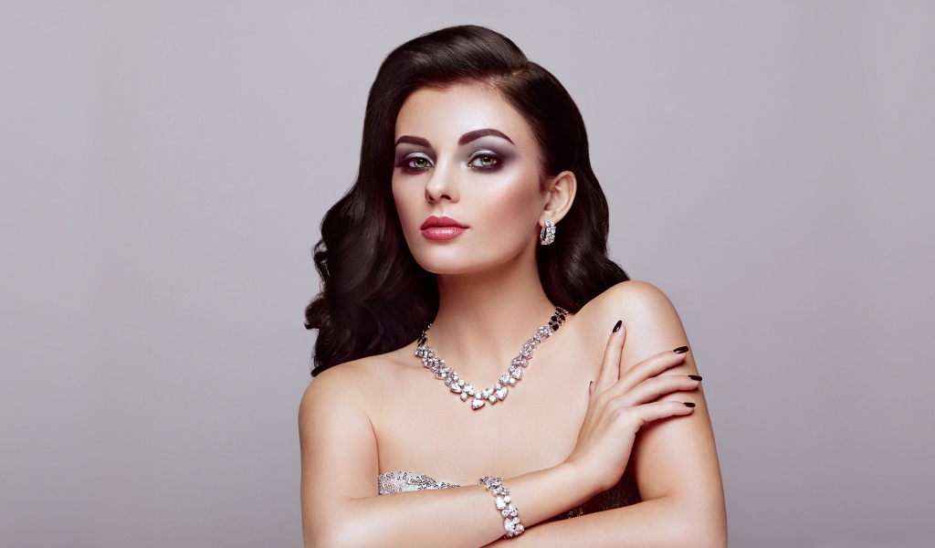 Красивая яркая брюнетка на сером фоне