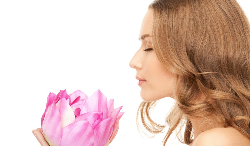 Красивая девушка шатенка наслаждается ароматом лотоса 