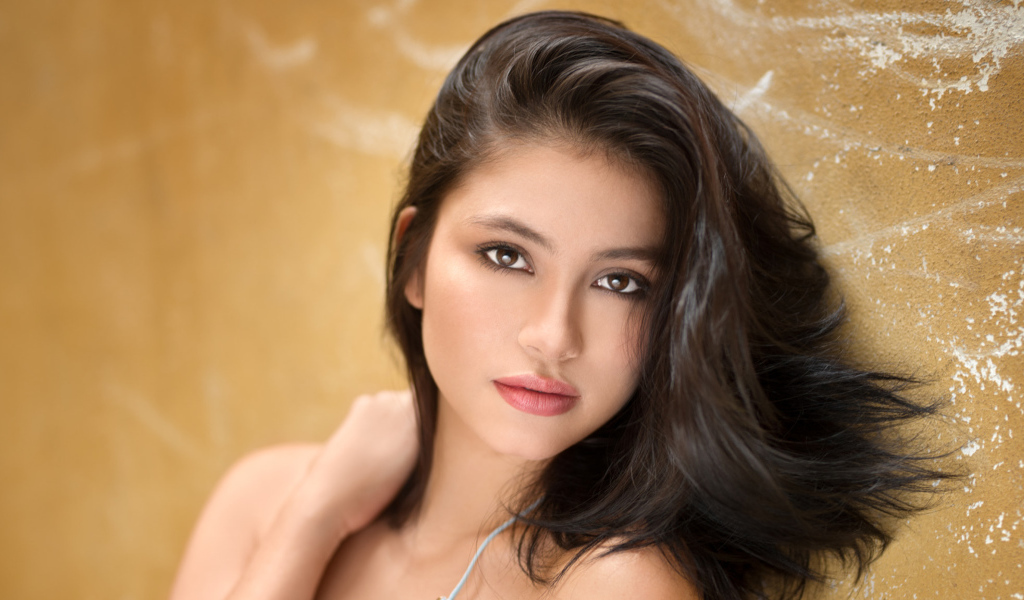 Красивая брюнетка на фоне стены 