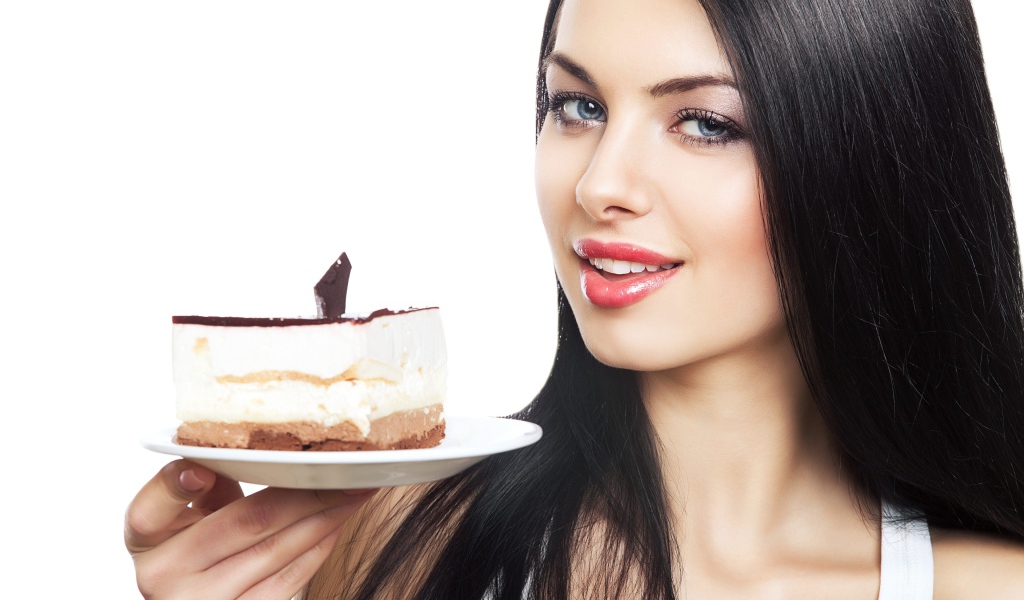Красивая брюнетка с куском торта на блюдце