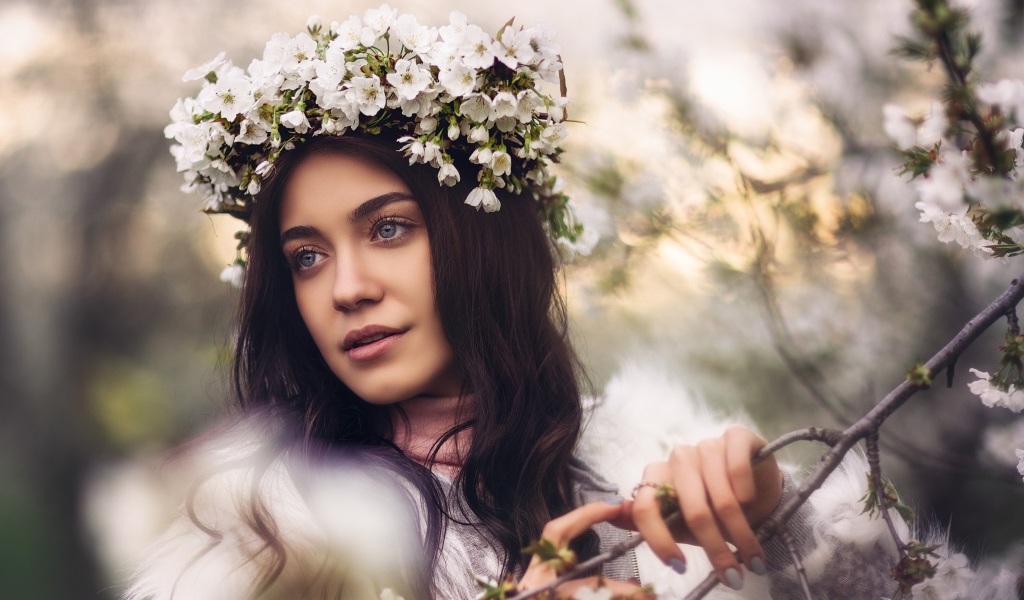 Красивая брюнетка с венком из цветов вишни на голове
