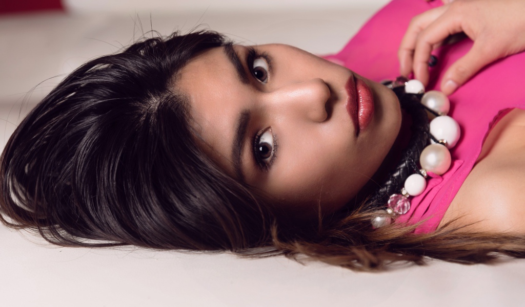 Красивая брюнетка с большими бусами на шее