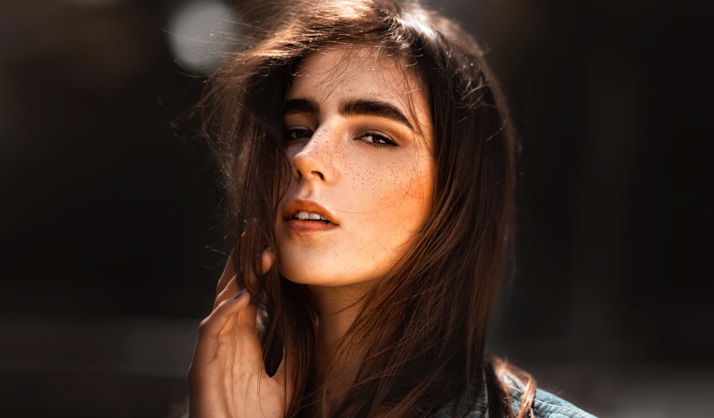 Красивая брюнетка с веснушками на лице