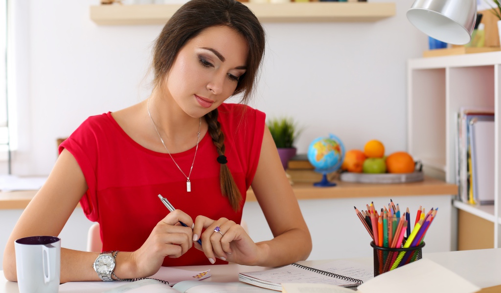 Красивая деловая девушка за столом с тетрадями