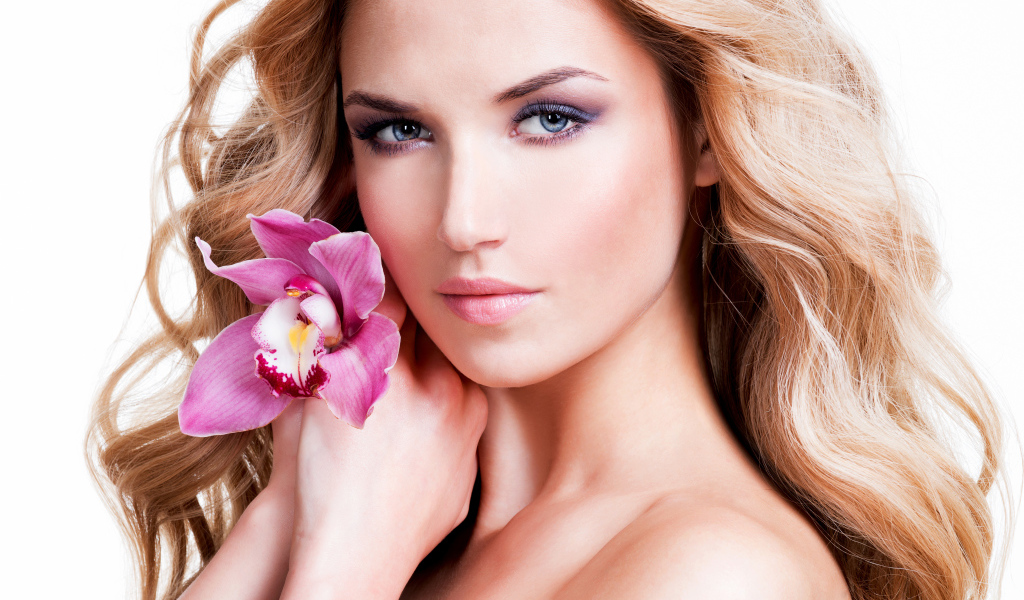 Красивая нежная блондинка с цветком орхидеи на белом фоне