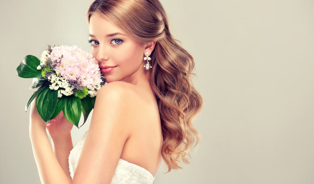 Красивая девушка невеста с букетом цветов на сером фоне