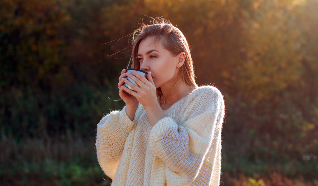 Красивая девушка пьет чай в теплом свитере